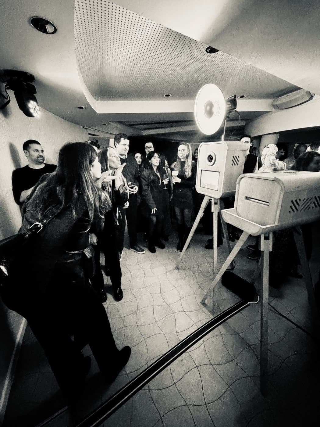 Evento con invitados alrededor del fotomatón vintage