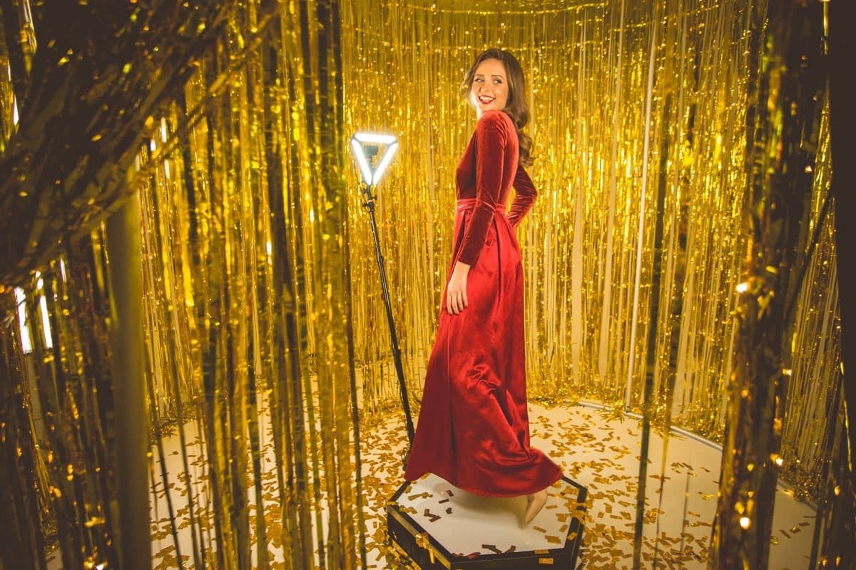 Invitada grabando un video en la plataforma Spinner 360 con fondo dorado