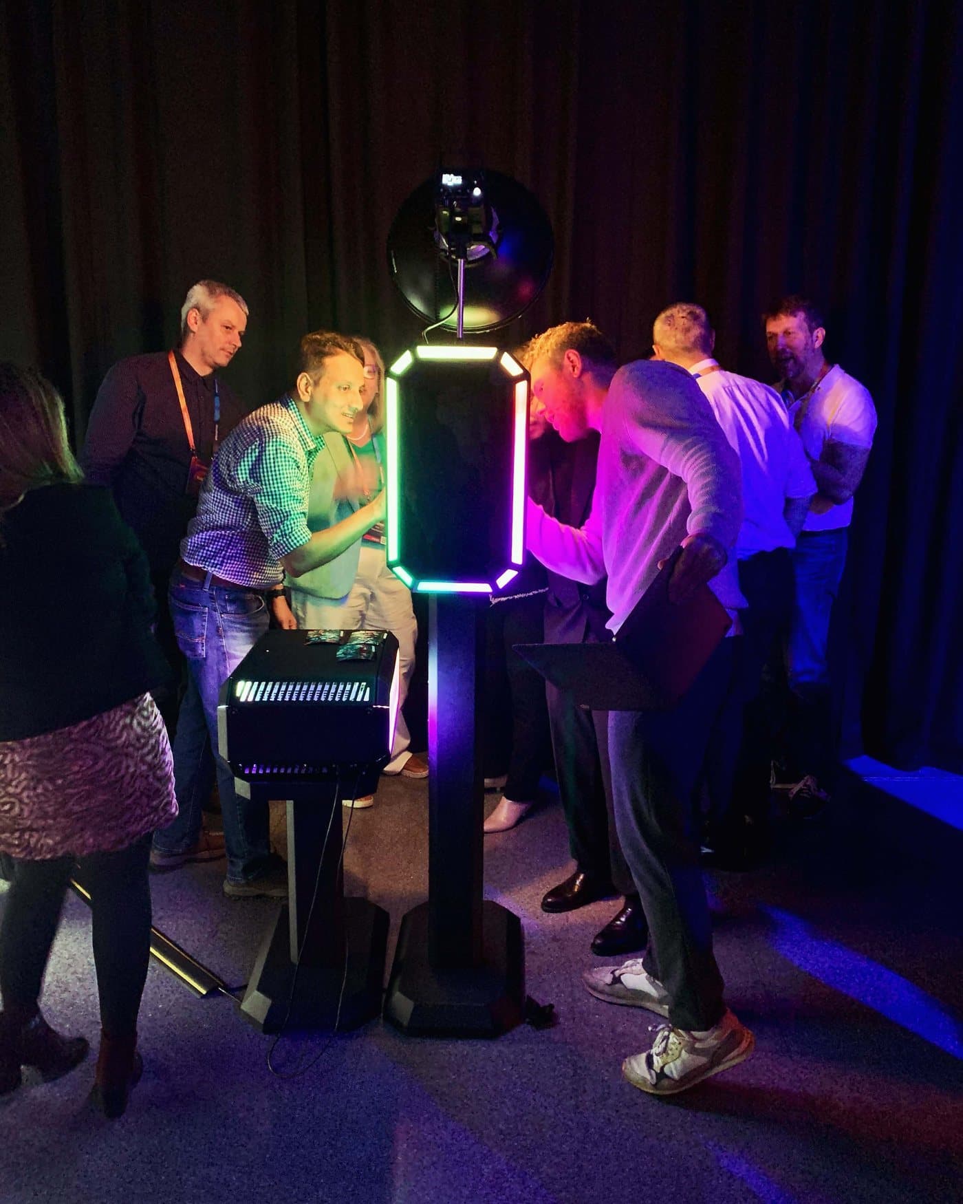 Invitados interactuando con el fotomatón LED durante un evento